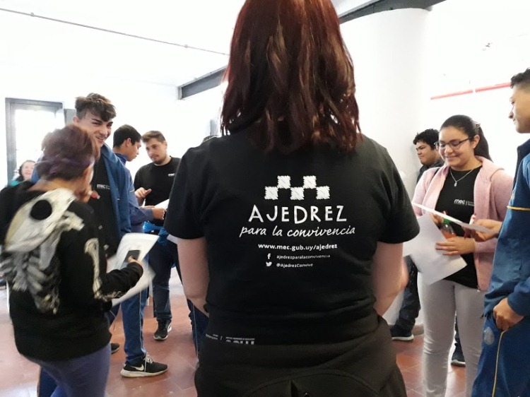 mujer de remera negra de espaldas con la inscripcion ajedrez para la convivencia