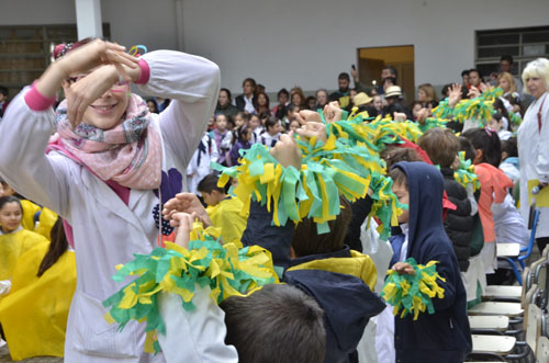 Maestra y niños bailando durante el espectáculo artístico