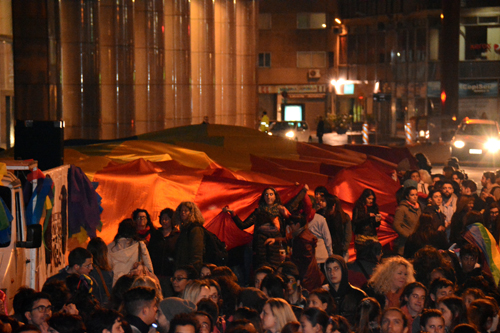 Gente caminando por 18 de julio y una bandera gigante detrás