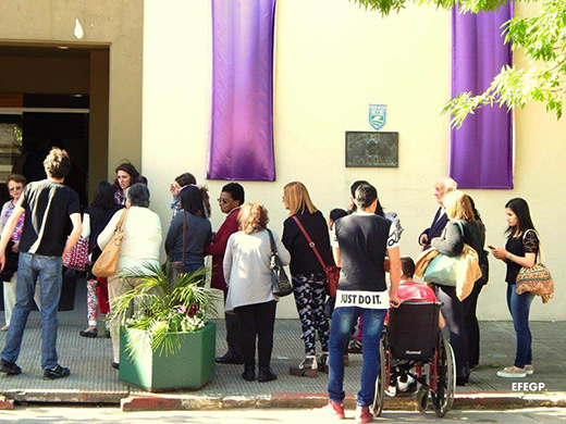 Personas haciendo fila, esperando para entrar a la obra en la vereda de la Casa de la Cultura de Treinta y tres